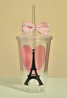 a cup with a bow on top and a straw in the shape of a eiffel tower