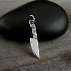 "This Chef Knife Charm comes with a silver jump-ring as pictured. Please note that photo is not to scale and may appear larger to show detail. Refer to exact measurements below. Additional attachments (lobster clasp, large-hole bead, necklace chains) are available from the charm-attachments drop-down menu.  For a visual example of the different attachments and what each one is best suited for, scroll through the photos until you see the example photo or visit https://etsy.me/2BY7DAW for detailed information.    { DETAILS } ★ Material: Sterling Silver  ★ Finish Color: Silver  ★ Measurements: 1/4\" x 7/8\" ★ Dimensions: Double-sided { SIMILAR ITEMS }  More kitchen themed items available from my shop: https://www.etsy.com/shop/treasuredcharms/search?search_query=kitchen { GIFT OPTIONS} Gift b Knife Pendant, Silver Knife, Butcher Knife, Pandora Beads, Culinary School, Large Hole Beads, School Gift, Chef Knife, Pandora Bracelet