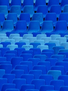 an empty blue stadium seat is seen in this image with only the seats facing forward