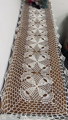 there is a table runner made out of crocheted doily on the floor