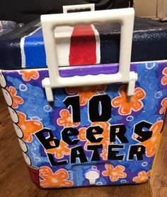 a close up of a piece of luggage on a wooden floor with the words 10 beers later painted on it