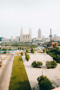 an aerial view of a parking lot in front of a cityscape with tall buildings