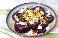 a white plate topped with beets covered in feta and sprinkles