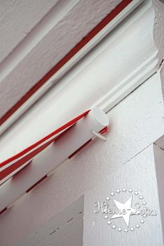 a red and white object is hanging on the side of a building with stars around it