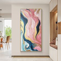 an abstract painting hangs on the wall above a dining room table