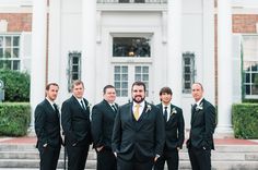 a group of men standing next to each other in front of a large white building