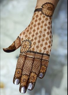 a woman's hand with hennap and flowers on her hands, showing the intricate