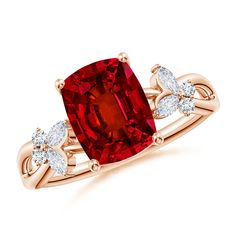 a red diamond ring with two white diamonds on the band and an oval cut stone in the center