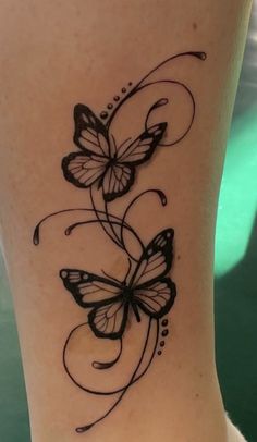 a black and white butterfly tattoo on the side of a woman's leg,