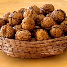 a basket filled with walnuts sitting on top of a wooden table