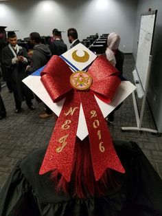 a person wearing a red and white graduation cap with a star on it's head