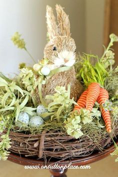 an easter bunny sitting in a nest with carrots