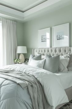 a white bed sitting in a bedroom next to two framed pictures on the wall above it