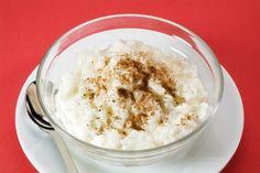 a glass bowl filled with whipped cream on top of a white plate