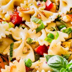 a pasta salad with tomatoes, broccoli and spinach