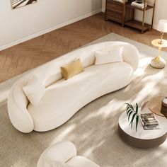 a living room filled with white furniture and lots of pillows on top of the couch