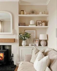 a living room filled with furniture and a fire place in front of a mirror on the wall