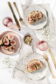 a table topped with plates filled with food next to silverware and utensils