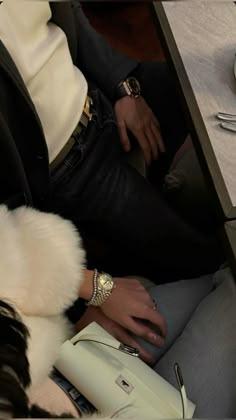 a person sitting at a table with a white purse and silverware on it's lap