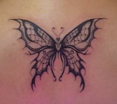 a woman's back with a butterfly tattoo on it