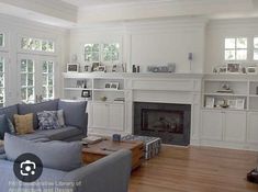 a living room filled with furniture and a fire place in the middle of a room