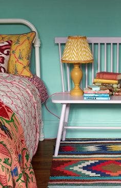 a bedroom with blue walls and colorful rugs on the floor next to a bed