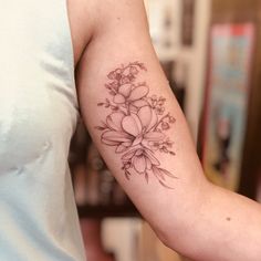 a woman's arm with a flower tattoo on the left side of her arm