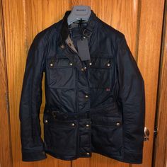 Jacket Is New W/ Original Tags: Shows No Visible Signs Of Wear. Retails For $950. The Iconic Roadmaster Is Crafted In Cambric Cotton. Its Shiny Waxed Finish Is Developed For Optimum Breathability And Water-Resistance. 2-Way Zip Fastening W/Snap Placket Buckle Waist Belt 4 External Pockets Stand Collar W/Tab Fastening And Velvet Lined Collar Adj. Snaps On Cuffs Check Lining Underarm Metal Air Vents Sleeve Logo Patch Commemorative Metal Plaque Reinforced Elbows & Shoulders Blue Utility Jacket With Flap Pockets For Winter, Designer Winter Outerwear With Flap Pockets, Designer Navy Outerwear For Work, Designer Navy Outerwear With Pockets, Luxury Blue Outerwear With Pockets, Classic Blue Winter Utility Jacket, Fitted Blue Outerwear With Flap Pockets, Designer Blue Outerwear With Padded Collar, Belstaff Jackets