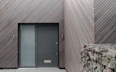 an entrance to a building with a metal door and brick wall next to the doors