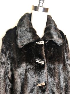 This is a faux fur, reversible jacket by Mackintosh, New England. The fur is soft and cozy and has the look of mink. The buttons look like horn and add a fun vintage flair. The reverse side is brown water resistant fabric, with fur trim. There is some creasing in the reverse fabric (see picture 7) which does not effect wearability. This is a stylish and very practical jacket, ready for whatever Mother Nature has in store. Size tag L. Check measurements carefully. Measurements taken with jacket l Classic Faux Fur Coat With Fur Trim, Classic Mink Faux Fur Coat, Classic Mink-colored Faux Fur Coat, Classic Mink Color Faux Fur Coat, Classic Fur Coat With Faux Fur Lining For Fall, Classic Fall Fur Coat With Faux Fur Lining, Winter Faux Fur Coat With Button Closure, Classic Mink Outerwear With Faux Fur Lining, Fall Mink Color Fur Coat With Faux Fur Trim