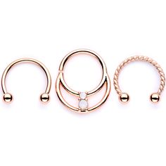 White Faux Opal Rose Gold Tone Twisted Horseshoe BCR Captive Ring Set Expand your septum jewelry collection with this set of three unique septum rings! This set features two 16 gauge horseshoe barbell rings, one with a twisted design, and one 16 gauge seamless circular ring. All three are 3/8" and made with rose gold tone anodized over 316L surgical grade stainless steel. The seamless circular ring comes complete with an iridescent white faux opal for that extra big of bling! Sold as a set of th Adjustable Internally Threaded Septum Ring, Elegant Adjustable Hoop Septum Ring, Adjustable Gold Metal Septum Ring, Adjustable Rose Gold Hoop Septum Ring, Unique Septum, Opal Body Jewelry, Conch Jewelry, Septum Rings, Gold Body Jewellery