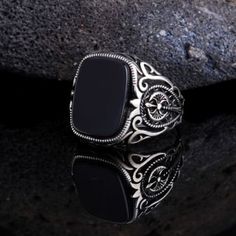 a black stone ring sitting on top of a rock