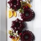 three pieces of fruit are arranged on a white plate with lemons and cherries