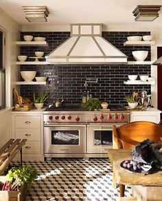 a kitchen with black and white checkered flooring, stove top oven and cabinets