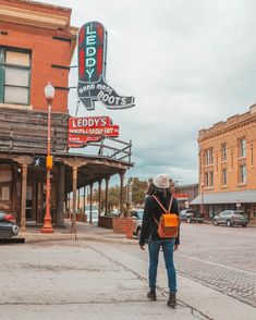 a person standing on the sidewalk in front of a building with a sign that says teddy's