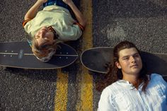 two people laying on skateboards next to each other