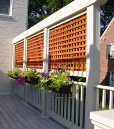 a wooden fence with flower boxes on it and some flowers in the potted planters