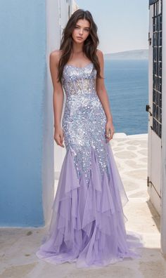 In soft lilac purple, this long sequin mermaid prom dress is a total feast for the eyes. With shimmering sequins from the sheer corset-style bodice to the hem, this long purple ruffled mermaid formal dress is a dazzling sight to behold whether you're attending prom, a pageant, or another black-tie event. The sheer-bodice long sequin evening gown has thin shoulder straps that lace-up over the cut-out back, while the hip-skimming long skirt has vertical ruffles that flow to the floor in glamorous Lavender Sequin Dress, Sparkly Purple Prom Dress, Sequin Mermaid Prom Dress, Pagent Dresses, Hoco 2024, Gowns For Prom, Gown For Prom, Sheer Corset, Sequin Evening Gowns