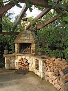 an outdoor fireplace with firewood stacked in it