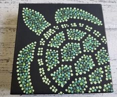 a black and green painting on wood with dots in the shape of a sea turtle