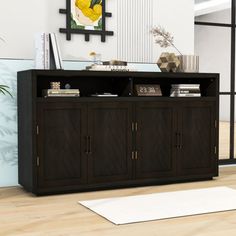 an entertainment center in a living room with wood floors and white rugs on the floor