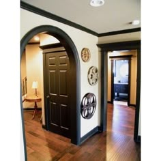 an entry way with black doors and wooden floors