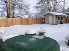 a yard covered in snow next to a fence