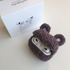 a teddy bear earbud holder next to a box