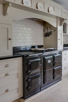 an old fashioned stove is in the middle of a kitchen with white cabinets and black counter tops