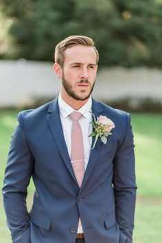 a man in a blue suit and pink tie