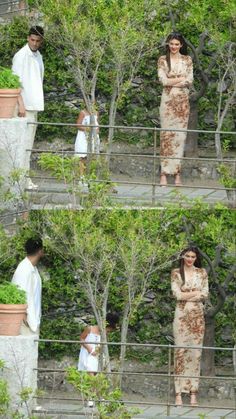 two women and a man are standing in front of some trees