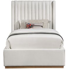 a white bed with a wooden headboard and foot board on it's side