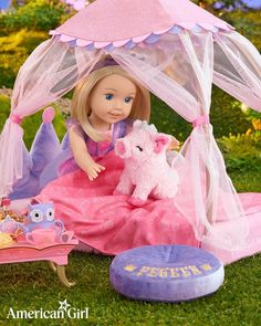 a doll is sitting in the grass with her pink and purple bed, toy horse, and princess tent