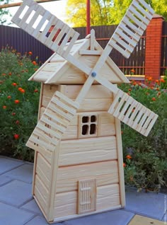 a wooden toy house with a windmill on top